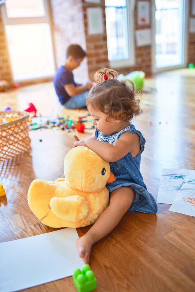 baby girl play with toy duck